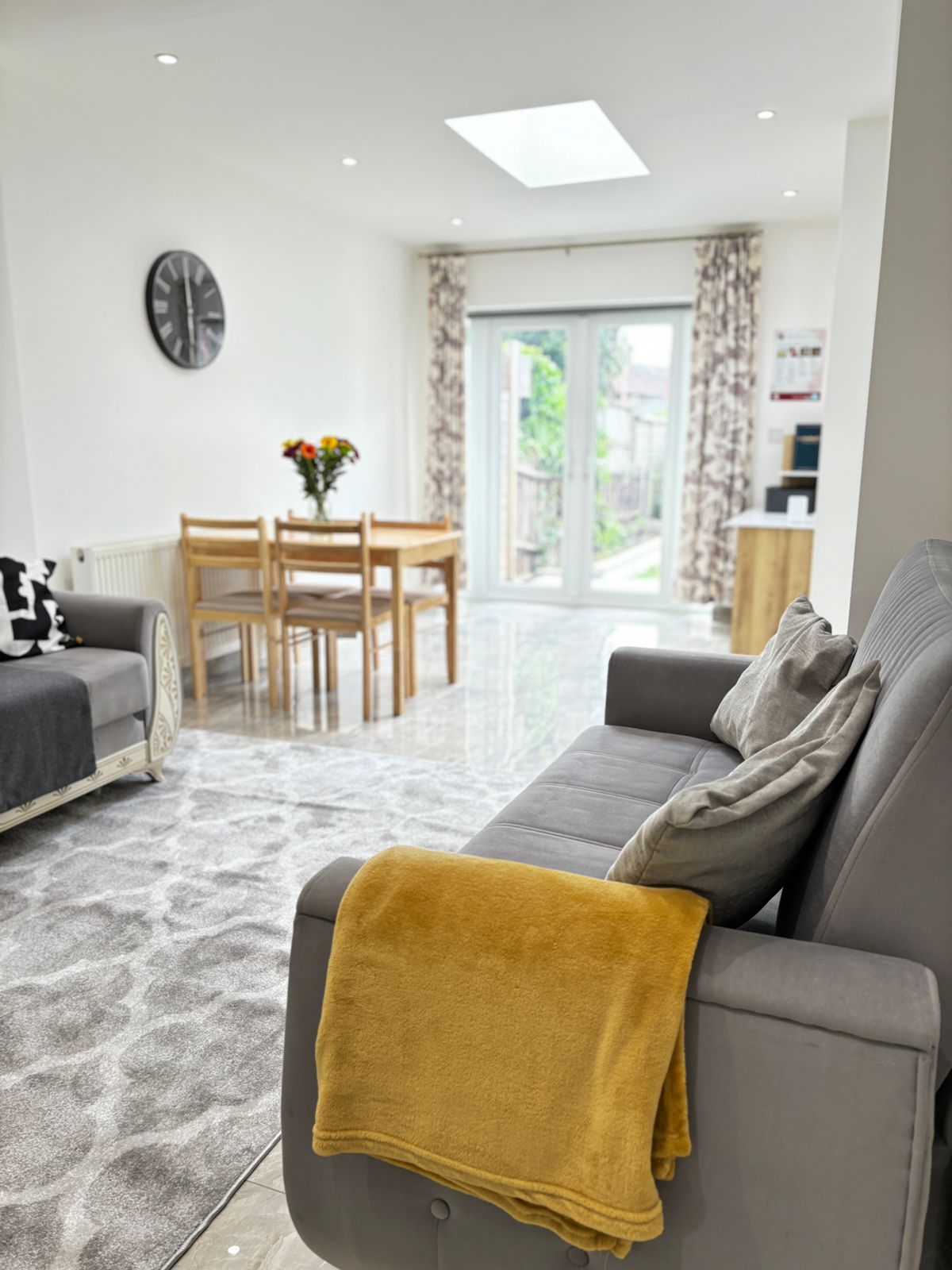 Bright, modern supported living accommodation with sofa, dining table, and garden view