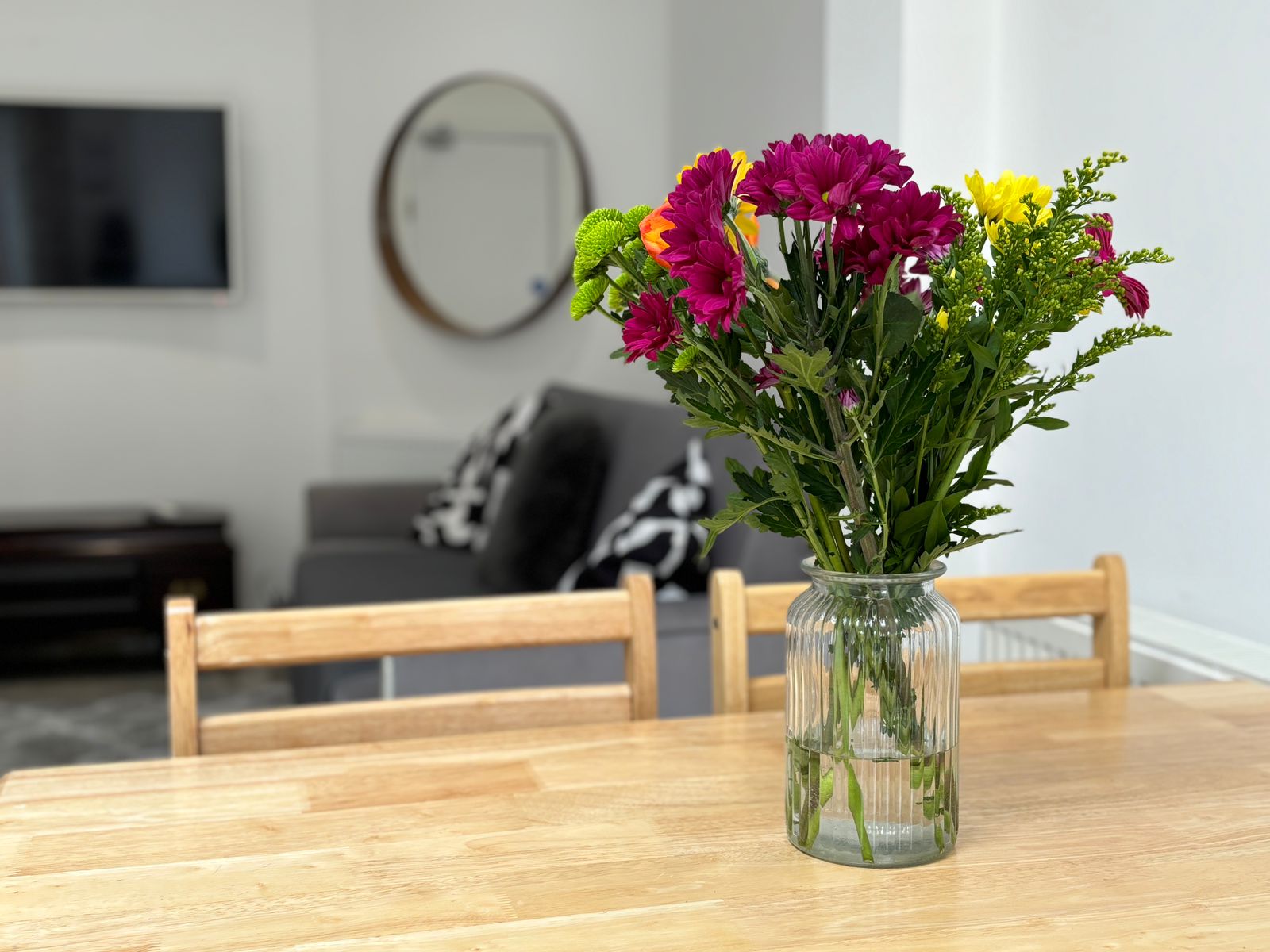 Bright, modern supported living accommodation with sofa, dining table, and garden view